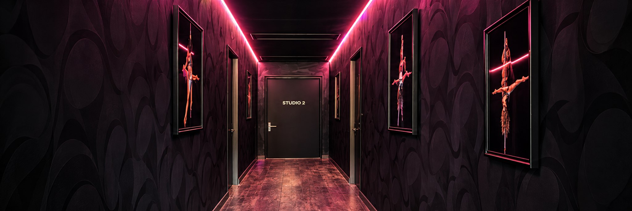 Le couloir du studio éclairé par les néons roses