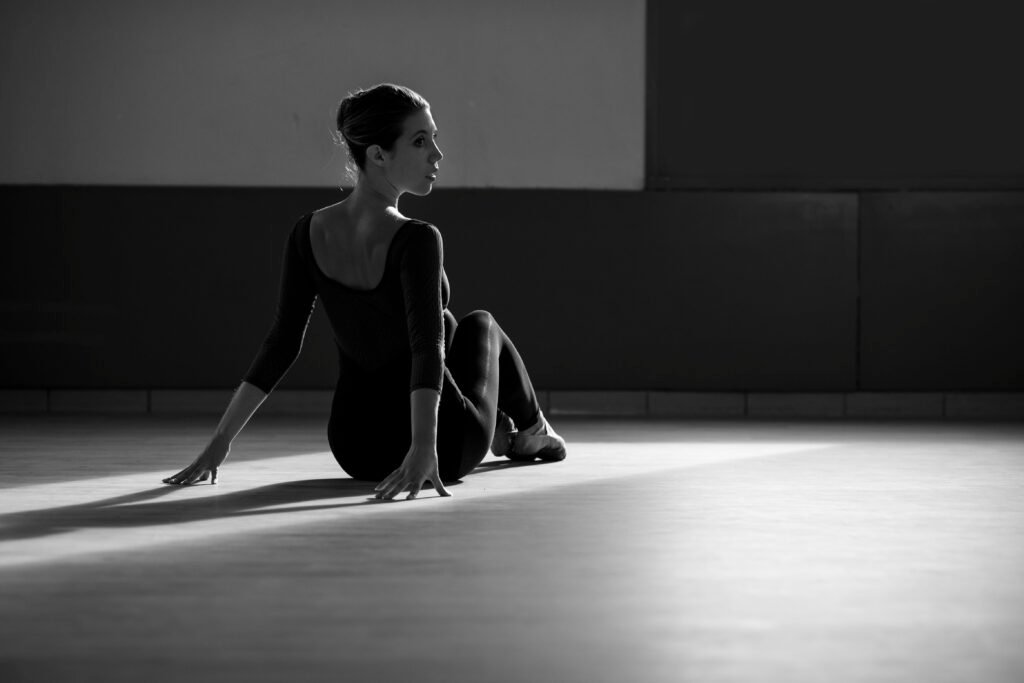 Anne, assise sur le sol du studio, dans une photographie en noir et blanc