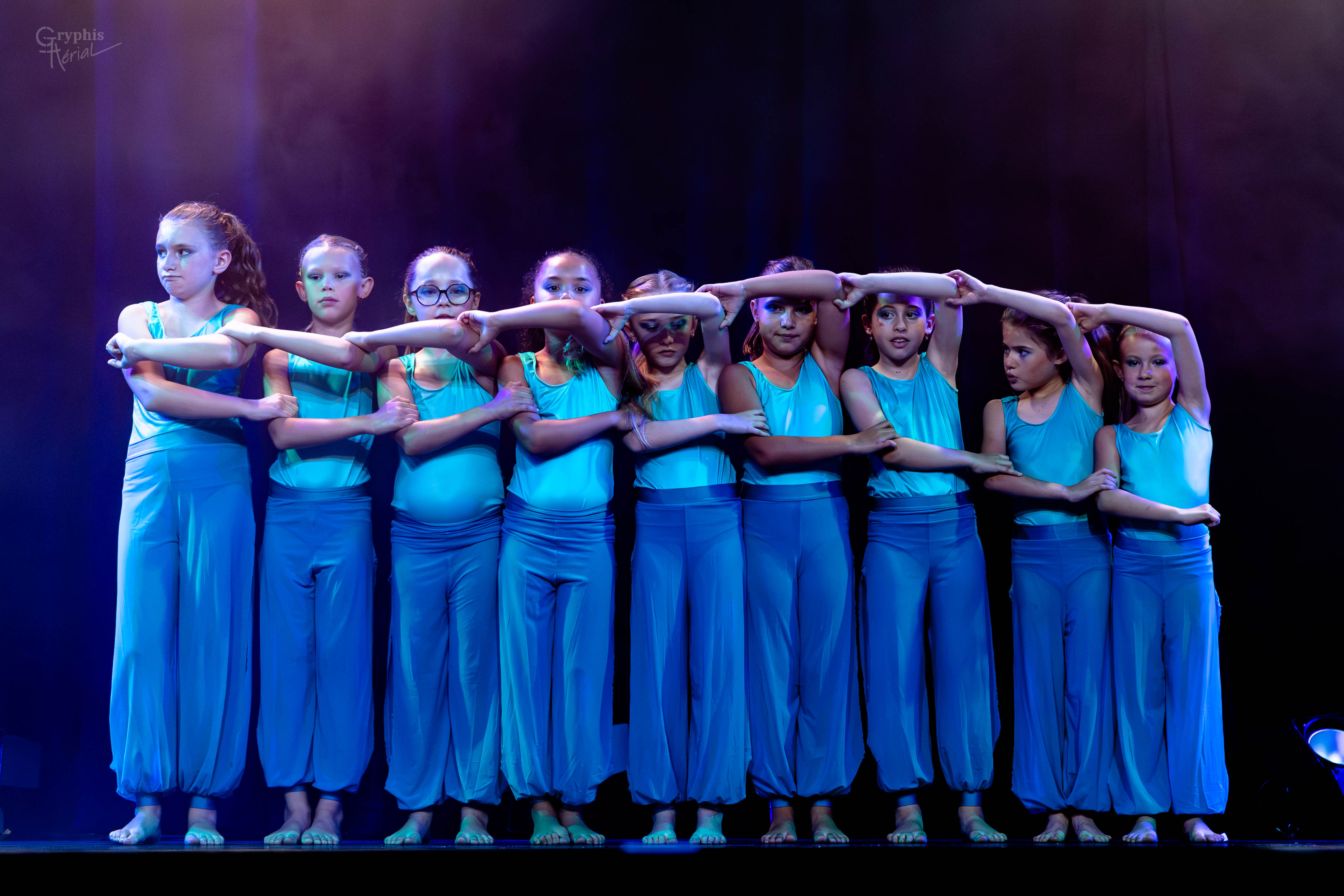 Élèves en costumes bleus dans une chorégraphie collective
